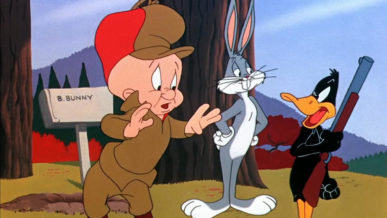 Elmer Fudd bald cartoon character standing with bugs bunny while daffy duck holds his gun