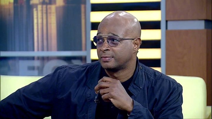Damon Wayans African American Actor sitting on couch wearing purple lens sunglasses