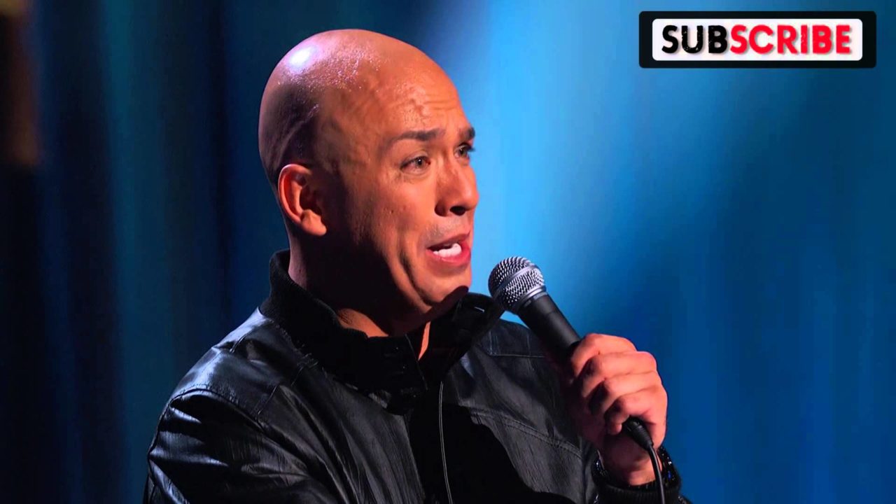 Jo Koy comic routine talking into mic pulling strange face with a bald head