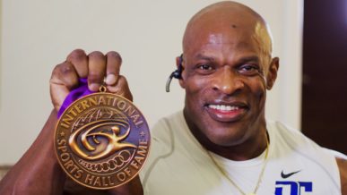 Ronnie Coleman black African American bodybuilder holding up International Sports Hal of Fame medal