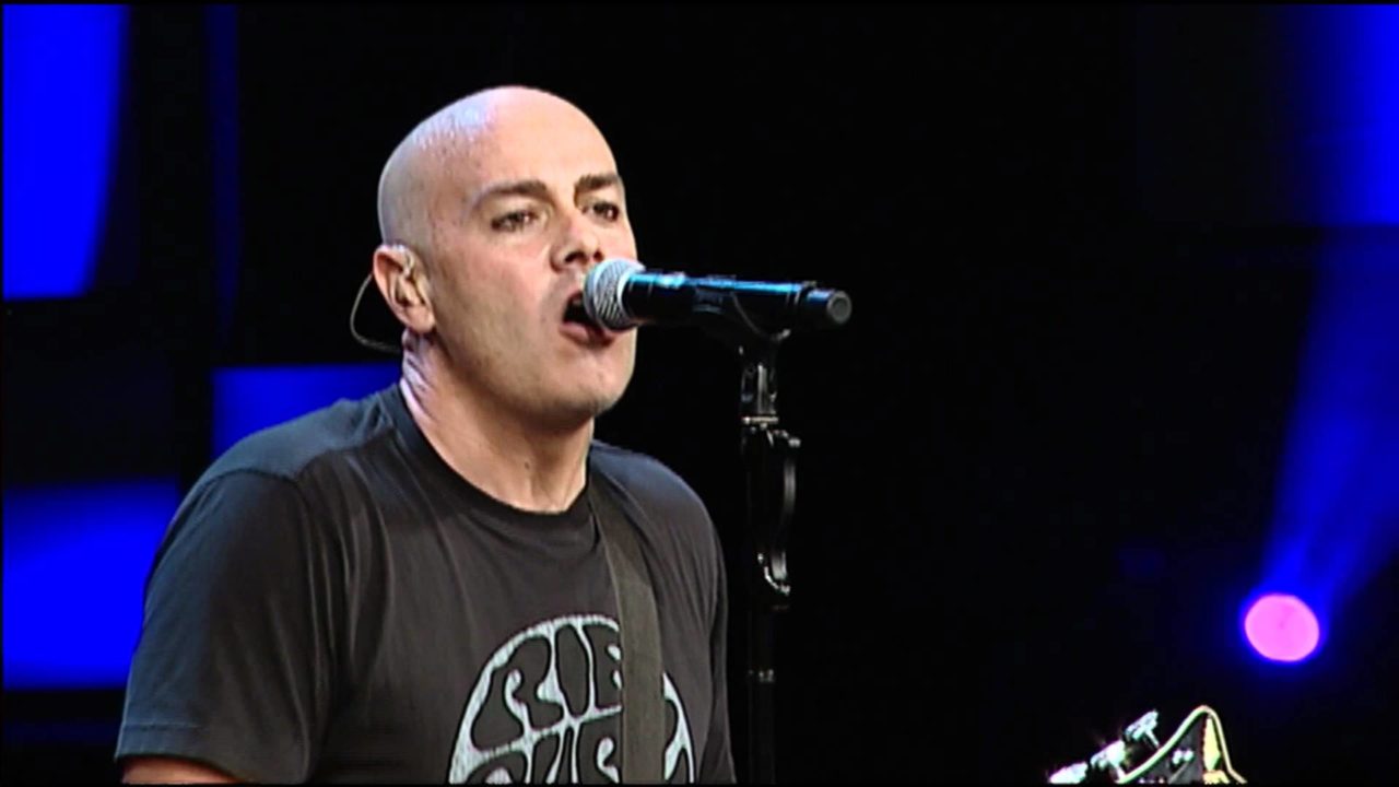 Peter Furler singing while playing guitar