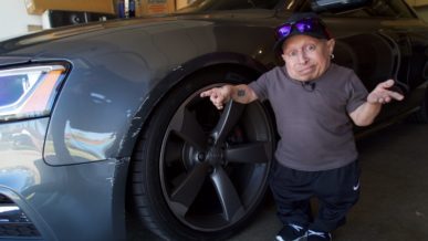 Verne Troyer pointing at damaged car