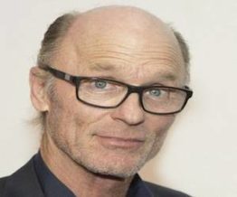 Ed Harris bald head wearing spectacles